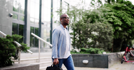 young businessman walks confidently through the city streets, managing finances and navigating the...