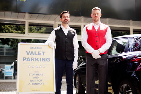 Skilled Valet Providing Exceptional Service Under Hotel Sign, Representing Top-notch Hospitality in City's Thriving Business Industry.の写真素材