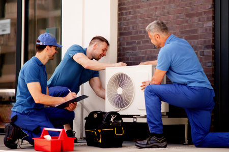 Skilled HVAC technician ensures efficient air conditioning in commercial buildings by installing...