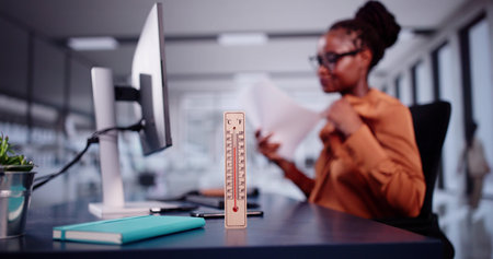 Thermometer In Front Of Businesswoman Working During Hot Weather In The Office