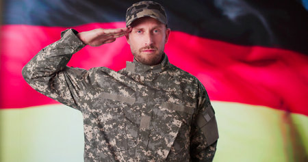 Portrait Of German Soldier Saluting In Front Of Flagの写真素材