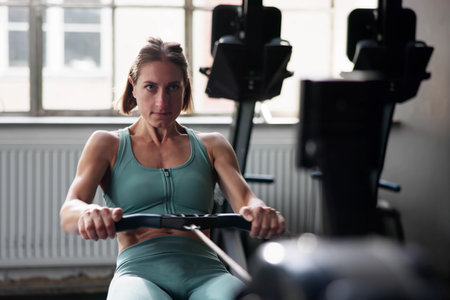 Woman Doing Gym Fitness Workout Exercise Using Rowing Machine