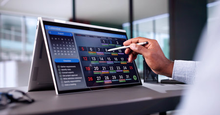Man Looking At Month Agenda In Calendar On Laptop Computer