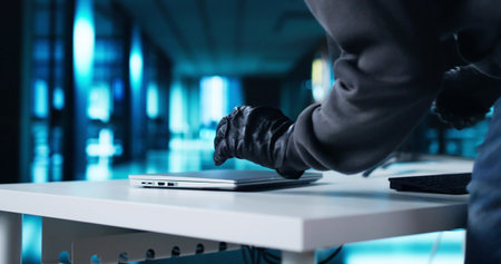 Thief Stealing Laptop Computer From Office At Nightの写真素材