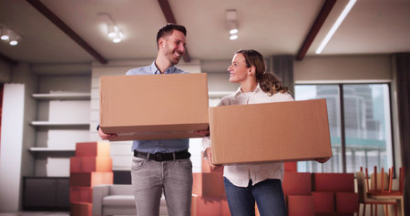 Happy Young Couple Moving Boxes In New Homeの写真素材