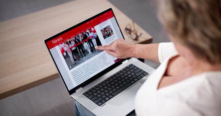 Watching Online News Article On Mobile Phone And Laptop. Electronic Newspaperの写真素材