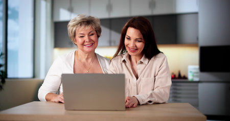 Teaching Tablet To Senior Woman. Assisting Mumの写真素材