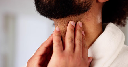 American man with sore throat undergoes thyroid and salivary exam.
