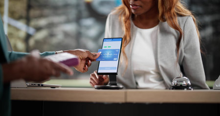 Young African woman making contactless payment at the store.