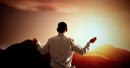 Faithful Man Kneels In Prayer, Seeking Hope In Sunset.の写真素材