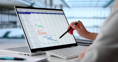 Female Project Manager Organizing Business Schedule On Convertible Laptopの写真素材