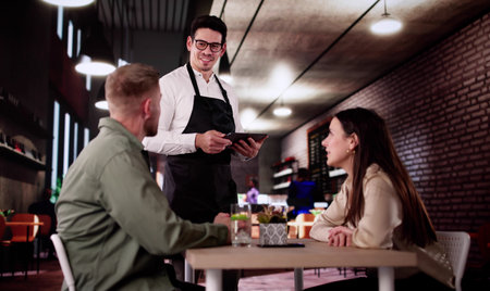 Romantic Waiter Takes Dinner Menu Order From Happy Elegant Couple.