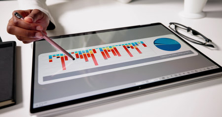 American Woman Using Laptop To Analyze Business Data And Graphs.