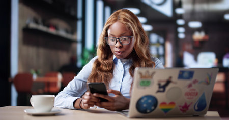 Young African American Woman Creatively Designing Graphics On Her Phone.の写真素材