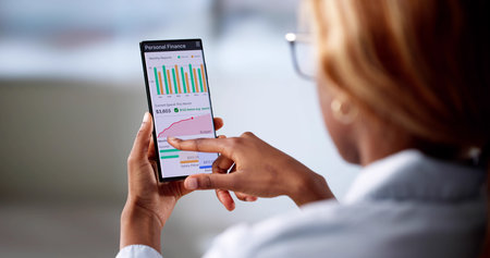 Smart Young African American Woman Tracks Finance On Her Phone.