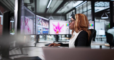 African American Woman Editing Photos On Computer Screen In Office.の写真素材