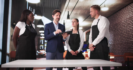 Manager And Owner Meet With Diverse Team At Popular Cafe.の写真素材