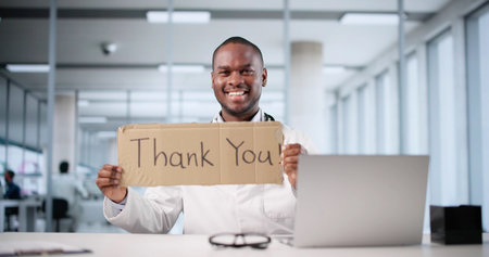Smiling African American Doctor Holding A Thank You Sign.
