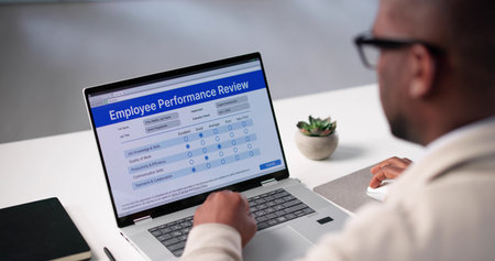 Digital Performance Review: Employee Holds Pen Filling Evaluation Formの写真素材