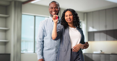 Happy Couple Holding Keys Showing New House To Family Portrait