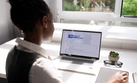Female African American Programmer Developing Software On Laptop In Officeの写真素材