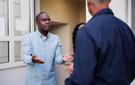 Neighbors Quarreling: Young Latino Couple Arguing Outside Apartment Entranceの写真素材