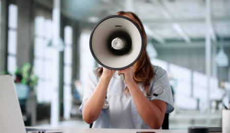 Nurse Announces Important News Through Megaphone, Excitement Lights Her Face.の写真素材
