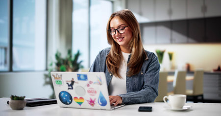 Young Woman Learning Graphic Design, Using Laptop In Kitchen.