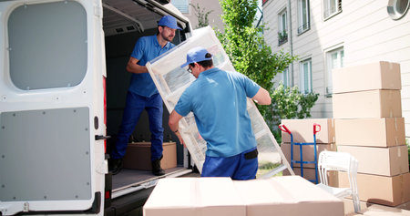 Hardworking Latino Movers Safely Transporting Furniture To Urban Homes.