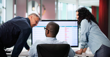 Analyzing Data On Multiple Computer Screens In A Business Office.