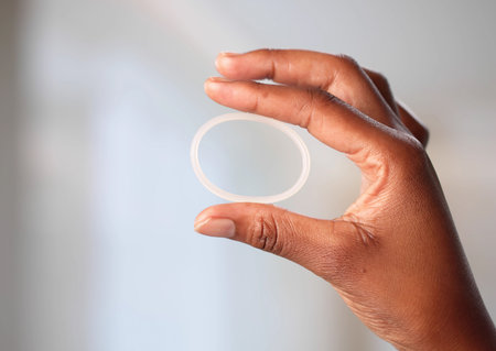 Young Woman Learning How To Use Black Contraceptive Ring Properly.の写真素材