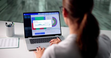 Analyzing Market Trends: Businesswoman Evaluates Data On Her Laptop