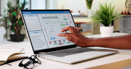 African American Woman Organizing Her Schedule On A Laptop Calendar.の写真素材