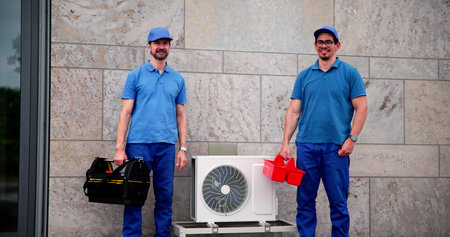 Professional HVAC Technician And Electrician Repair Air Conditioning Outside Officeの写真素材