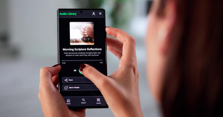 Female Preacher Streaming Worship Podcast On Smartphone By Ocean Rocks.の写真素材