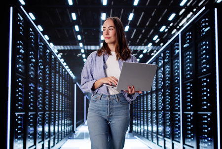Focused Female Computer Scientist Configuring Systems In Data Center Server Room.