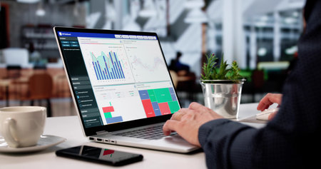 Businessman Analyzing Data Charts On Laptop In Cafe