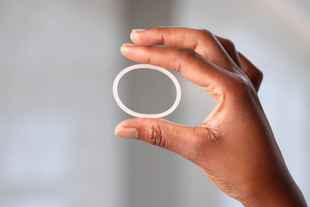 Young African-American Woman Holds Black Contraceptive Ring For Vaginal Use.