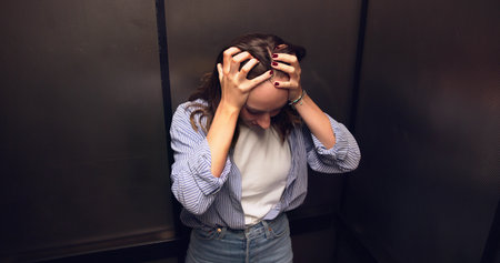 Female Elevator Technician Comforts Woman Trapped In Claustrophobic Spaceの写真素材