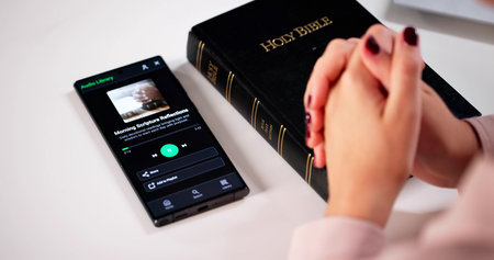 Devout Christian Woman Engrossed In Audio Bible Study Sessionの写真素材