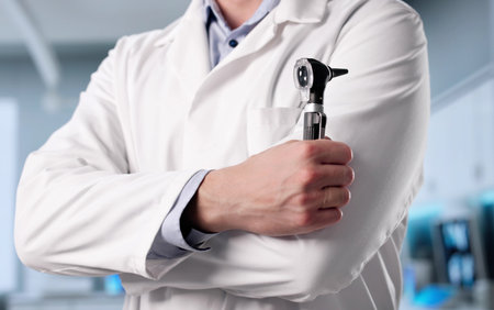 Young Caucasian Male Audiology Professional Checks Patient's Ear Infection Carefully.の写真素材