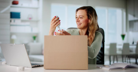 Woman Receiving Online Delivery: Unboxing Parcel With Happy Expression.の写真素材