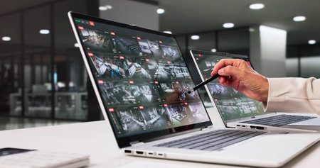 Monitoring Security System Footage On Laptop, Woman Consults Elderly Client.の写真素材