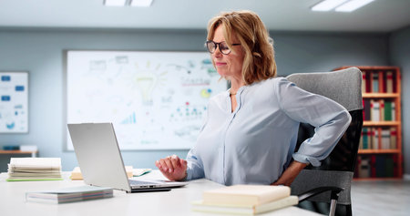 The Businesswoman's Painful Struggle With Lower Back Posture At Workの写真素材