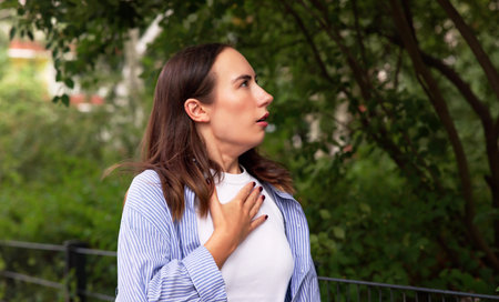 Allergic Woman Sneezing Amidst Summer Pollen Outdoors In Park.の写真素材
