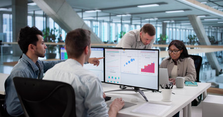 Multiracial Team Analyzing Performance Data On Computer Dashboard Screenの写真素材