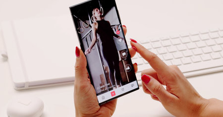 Young Woman Scrolling Through Short Videos On Mobile Phone. Possible Professions: Journalist, Social...