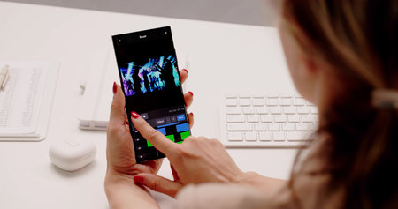 Creative Woman Editing Videos And Designing Pictures On Smartphone Appの写真素材