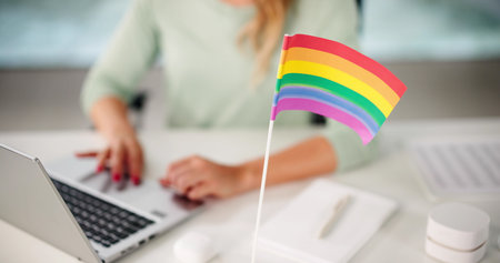 Female Employee Texting In Inclusive Business Office Supporting LGBTQ Equalityの写真素材