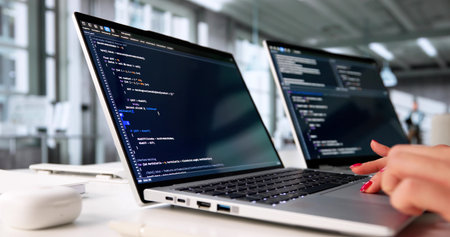 Young Woman Coding Software In Office On Laptop Computer Screen.の写真素材